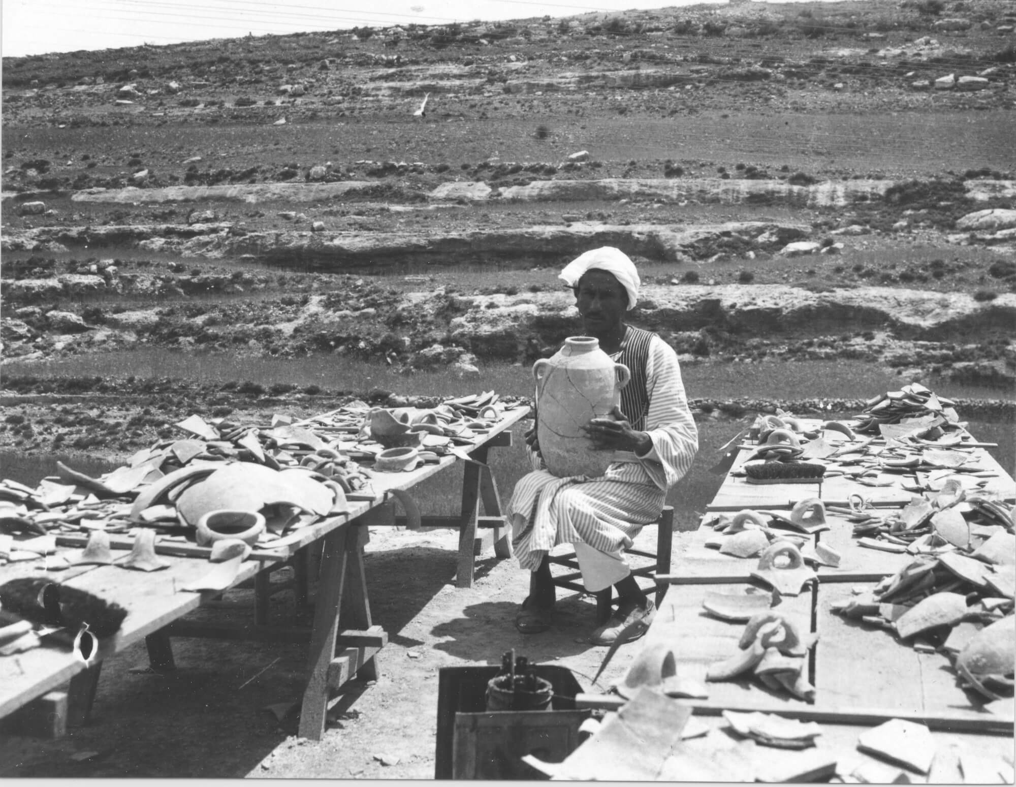 Figure 8. Reis Tantawi restoring pottery on the terrace at Maloufiya, 1932. Badè Museum photographic archive A920. Photographic negative. Courtesy of the Badè Museum, Pacific School of Religion.