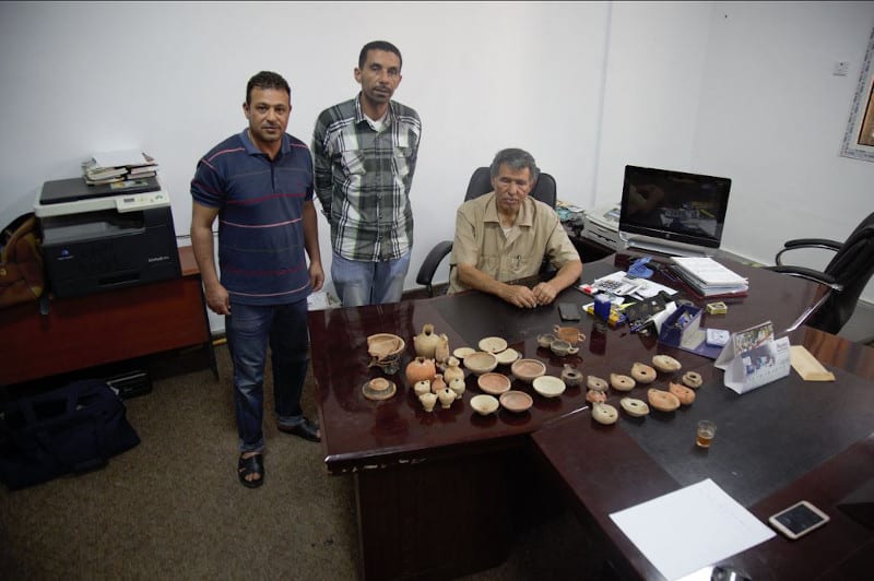 Younis and Salah Sadullah with a portion of the archaeological collection hidden in the home of the Al Kawash family while the city was occupied by ISIS and returned safely to the Department of Antiquities in 2018. (DoA Shahat)