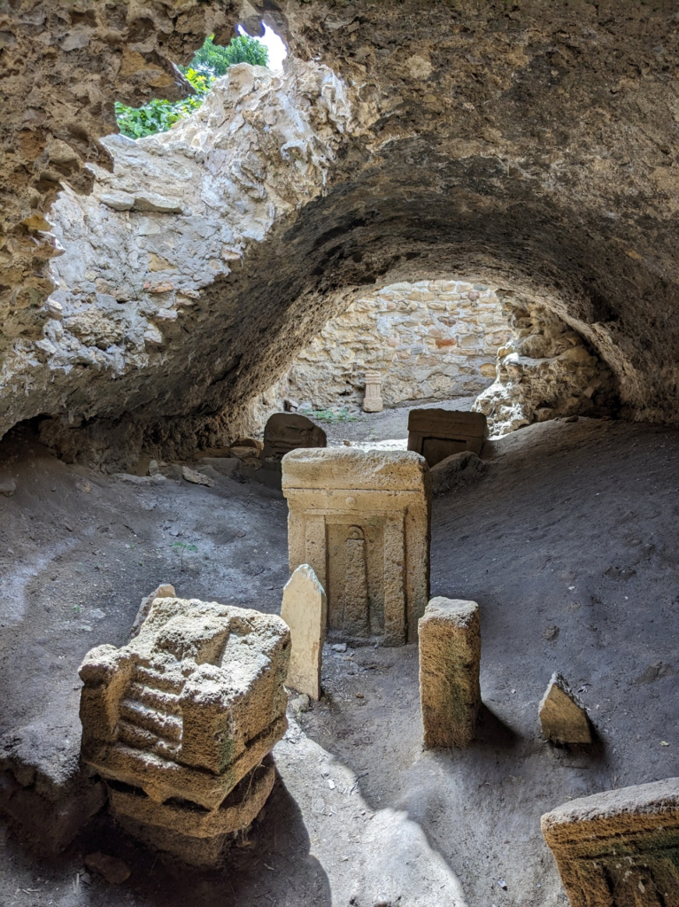 Votive stelae and a miniature stone throne from the “Precinct of Tanit” at Carthage, covered over by a Roman aqueduct channel (photo by H. Dixon).