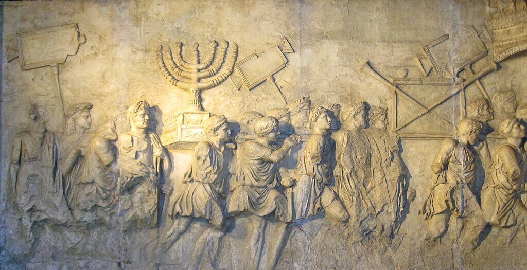 Replica of one of the interior relief panels of the Arch of Titus in Rome (constructed 81 CE) depicting Roman figures carrying war spoils from Judea in the triumphal procession of 71 CE, following the fall of Jerusalem to the Roman army. ANU Museum of the Jewish People. Photo: Sodabottle / Wikimedia Commons, CC BY-SA 3.0 DEED.