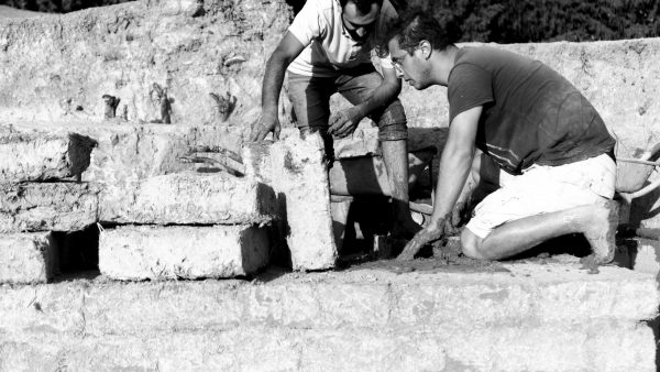 Onur Hasan Kırman and Hikmet Eslikızı laying a course of mud bricks