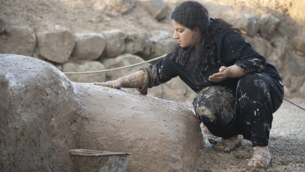 Büşra Hekimoğlu is mud plastering the courtyard walls of the Late Bronze Age palace