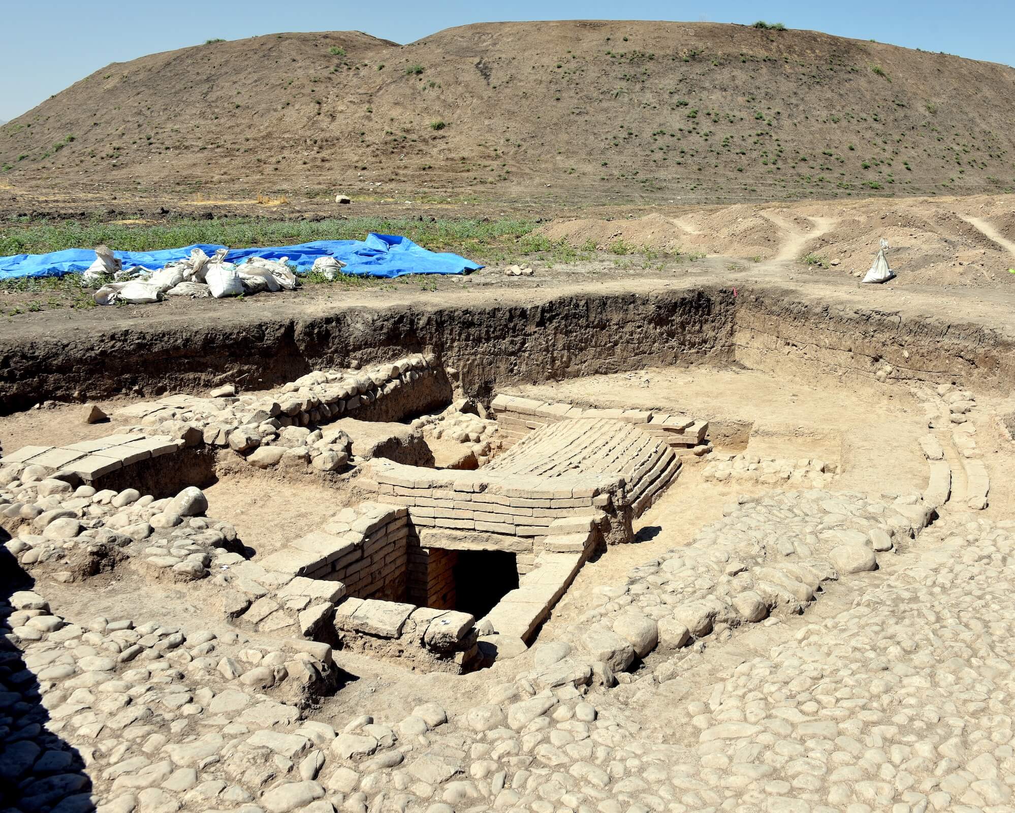 Example of a vaulted tomb at Yasin Tepe, Sualymaniayh, Shahrizor Plain, Iraq, 1st millennium BCE. Tombs like these often held more than one household member and were meant to be accessible to the living family, either to bring offerings down to the deceased or to bury another member. Photo: Osama Shukir Muhammed Amin FRCP (Glasg), CC BY-SA 4.0, via Wikimedia Commons (https://commons.wikimedia.org/wiki/File:1st-millennium_BCE_grave_at_Yasin_Tepe,_Shahrizor_Plain,_Sulaymaniyah_Governorate,_Iraqi_Kurdistan.jpg)