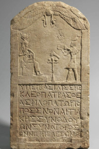 Egyptian stele showing Cleopatra dressed as pharaoh paying homage to the enthroned goddess Isis suckling Horus. Musée du Louvre E27113, Paris (© 2015 Musée du Louvre / Christian Décamps).