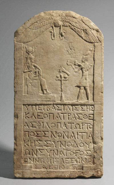 Egyptian stele showing Cleopatra dressed as pharaoh paying homage to the enthroned goddess Isis suckling Horus. Musée du Louvre E27113, Paris (© 2015 Musée du Louvre / Christian Décamps).
