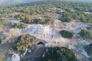 An aerial view of the pyramidal funerary monument and the opening of the collapsed burial cave to its north, looking west (Photo: T. Rogovski).