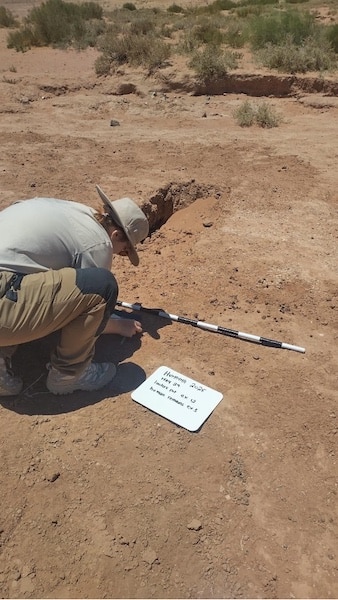 Hall-fig4 Setting up the north arrow before photographing a looter’s pit that contained human remains.