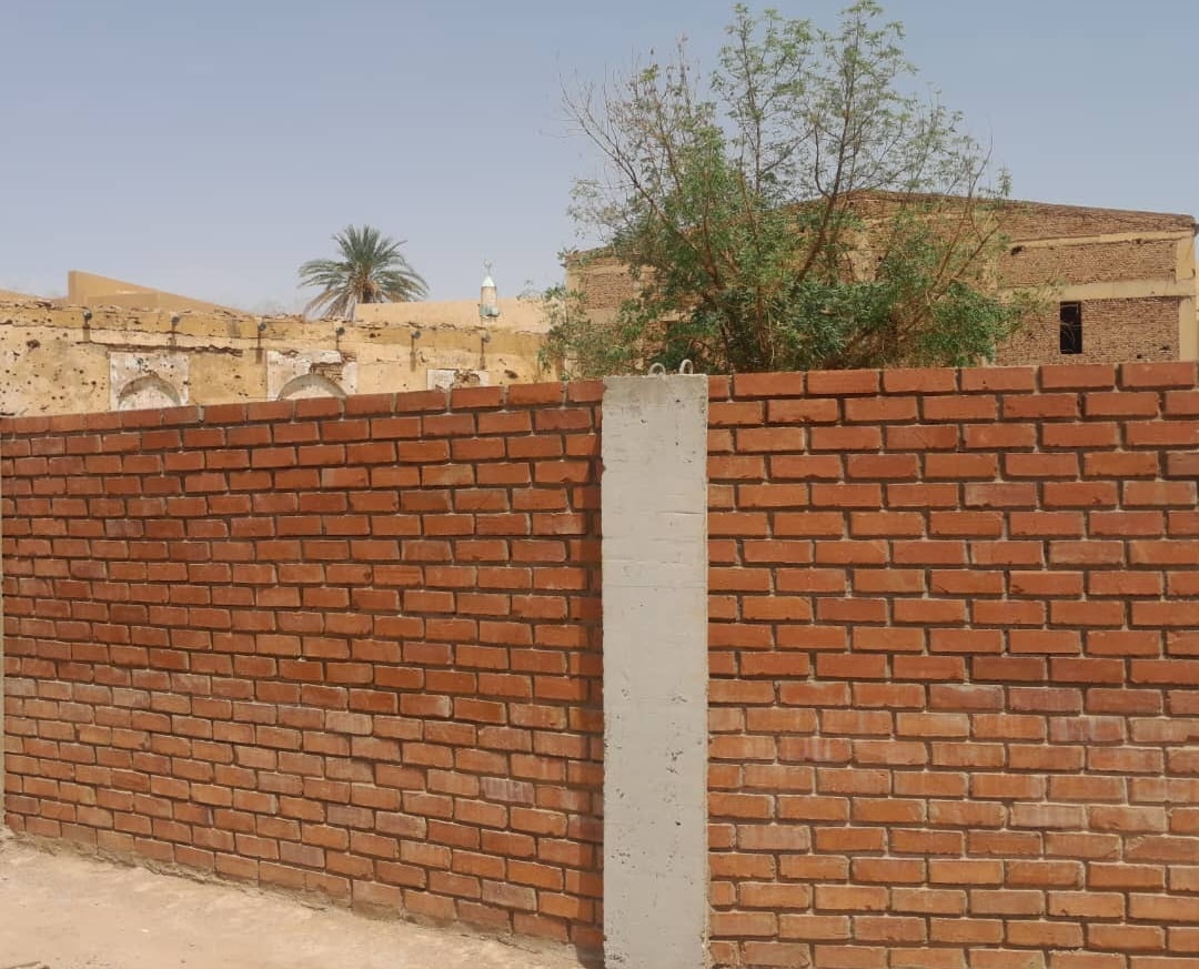 SNM_Update_3 Section of completed wall with damaged museum storage behind.