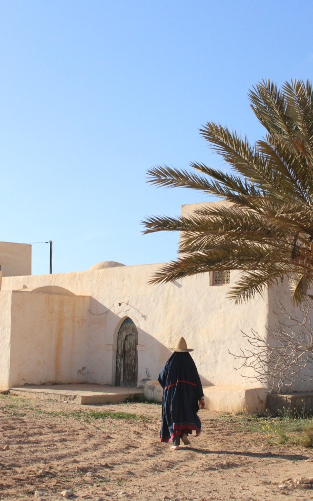 A WOMAN IN FRONT OF HER HOUSE | صورة لامرأة جربية امام حوشها